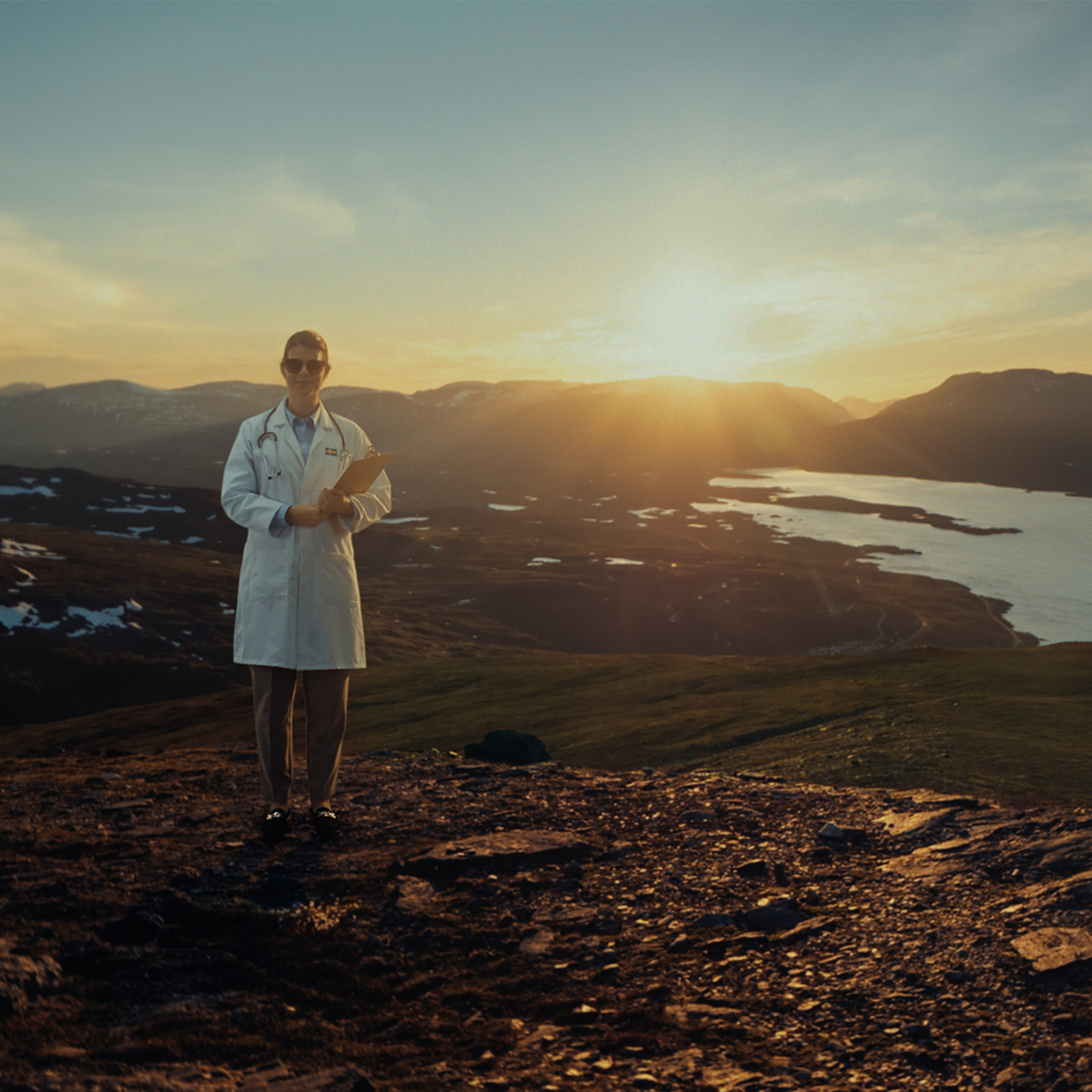 Doctor in a white coat on a Swedish mountain at sunset