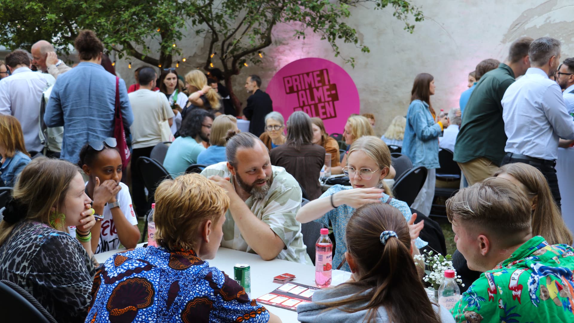 People talking around tables at the Prime i Almedalen garden event