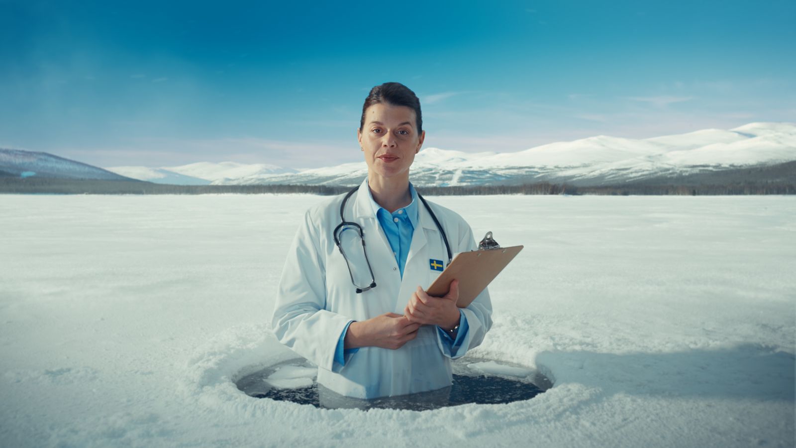 Doctor in a white coat standing in a hole in a frozen lake